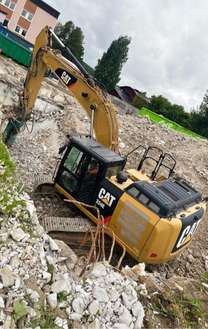 Demoleringsgruppen river gammal byggnad med grävmaskin